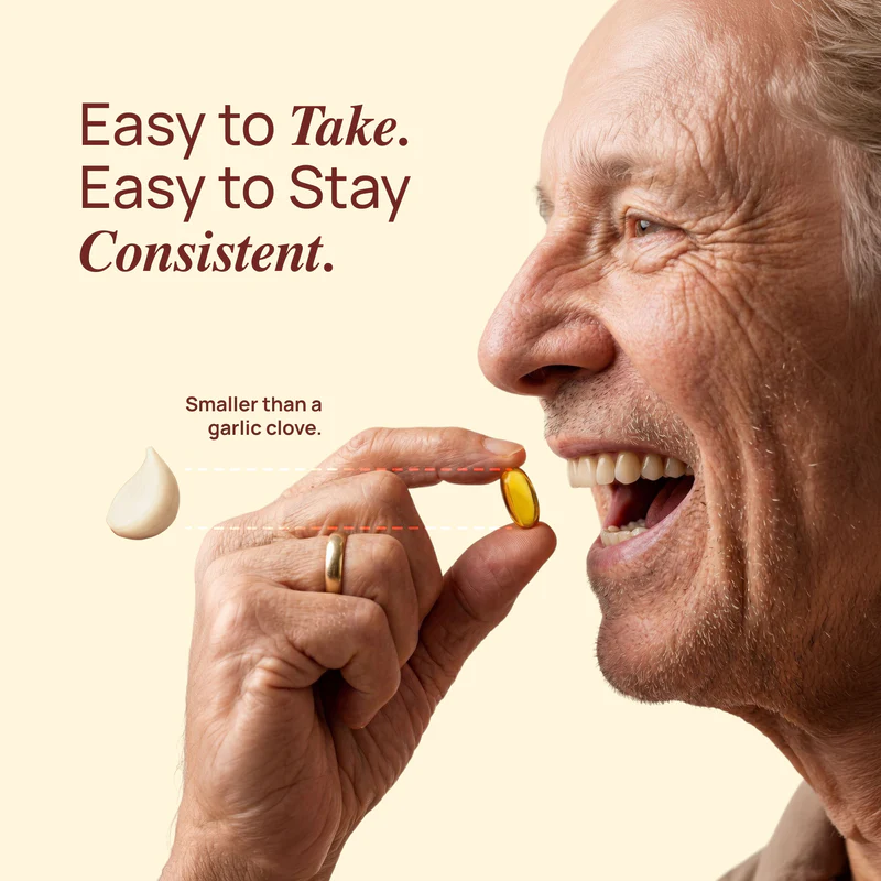 Smiling older man holding a Gaarlic softgel — smaller than a garlic clove